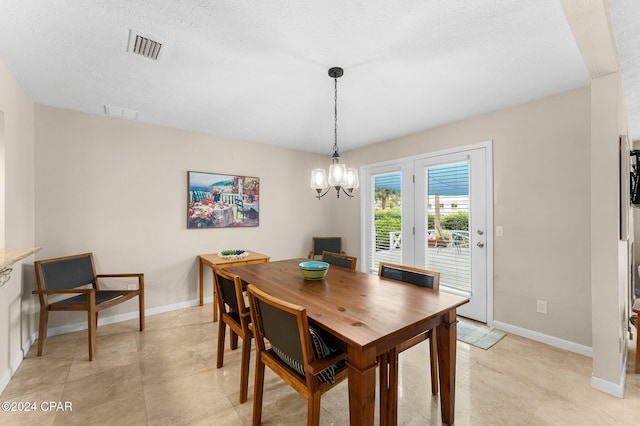 dining room featuring a chandelier and a textured ceiling