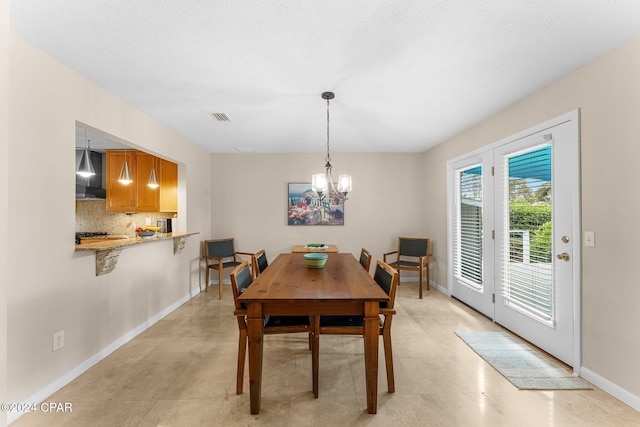 dining area featuring a chandelier and a textured ceiling