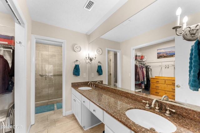 bathroom featuring tile patterned flooring, vanity, and a shower with door