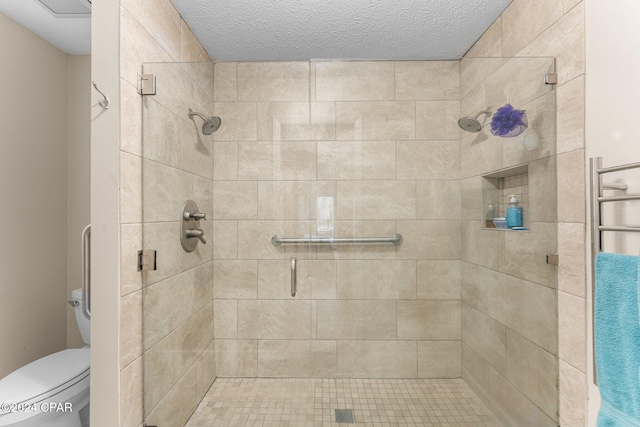 bathroom featuring a textured ceiling, toilet, and walk in shower