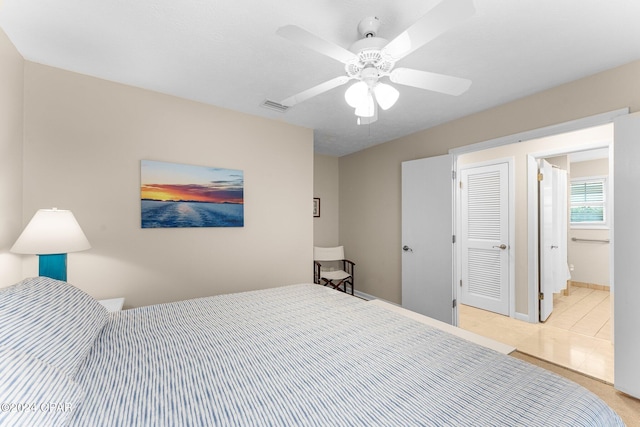 carpeted bedroom with ensuite bathroom and ceiling fan