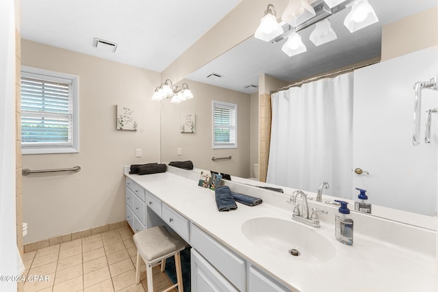 bathroom featuring tile patterned flooring, vanity, toilet, and curtained shower