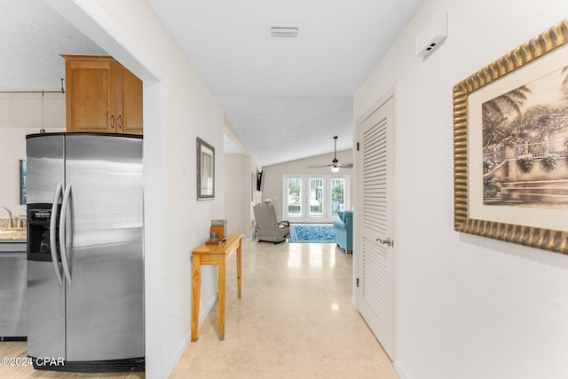 corridor featuring french doors, a textured ceiling, vaulted ceiling, and sink