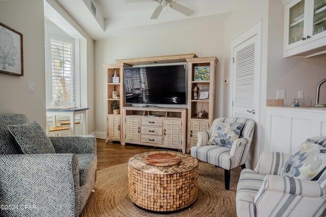 living room with dark hardwood / wood-style flooring and ceiling fan