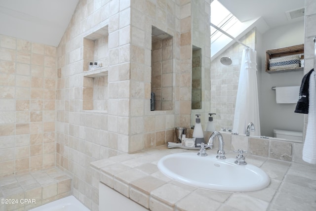 bathroom with toilet, curtained shower, and sink