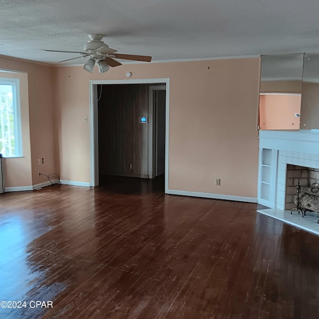 unfurnished living room with dark hardwood / wood-style floors, ceiling fan, ornamental molding, and a textured ceiling