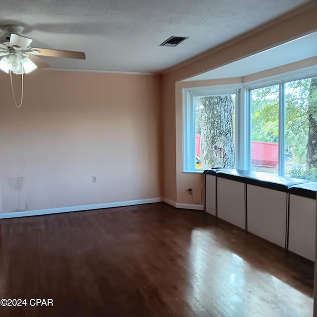 spare room featuring a textured ceiling, hardwood / wood-style flooring, ceiling fan, and crown molding