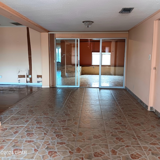 unfurnished room with a textured ceiling and ornamental molding