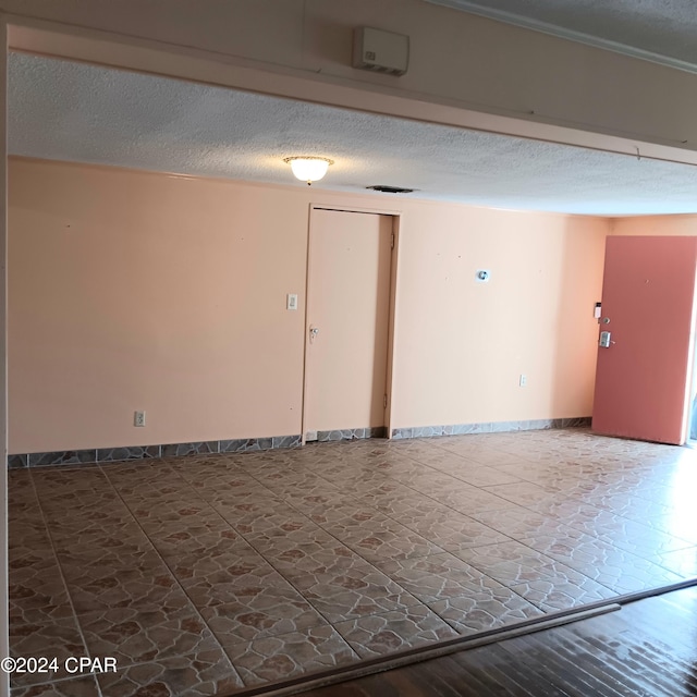 unfurnished room featuring a textured ceiling