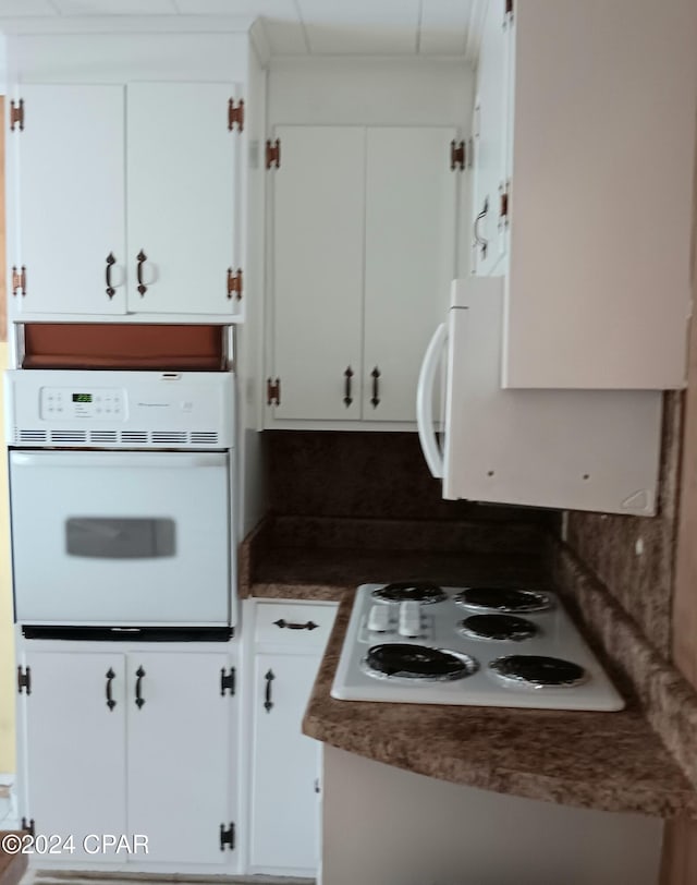 kitchen featuring white appliances and white cabinetry