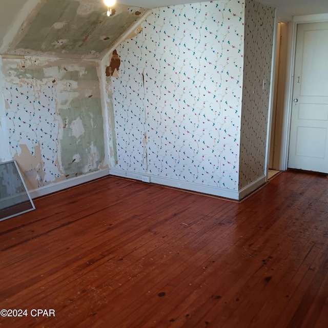 empty room featuring wood-type flooring and lofted ceiling