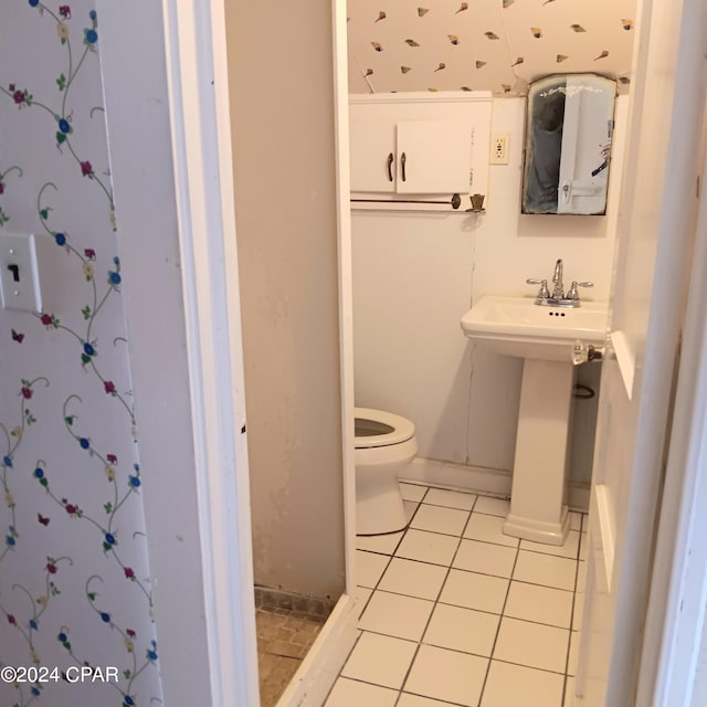 bathroom with toilet, tile patterned floors, and sink