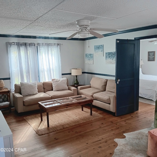 living room with a paneled ceiling, ceiling fan, and wood-type flooring