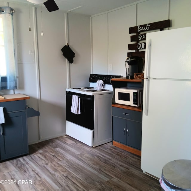 kitchen featuring white appliances and dark wood-type flooring