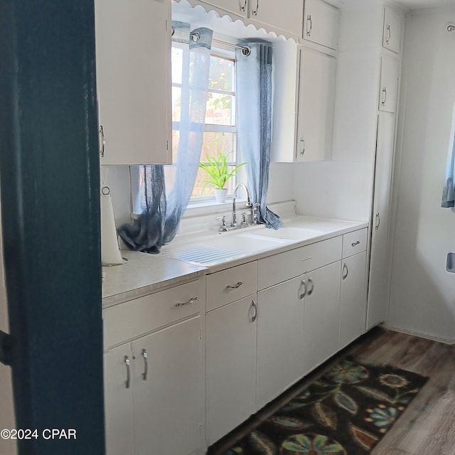 kitchen featuring white cabinets, dark hardwood / wood-style flooring, and sink