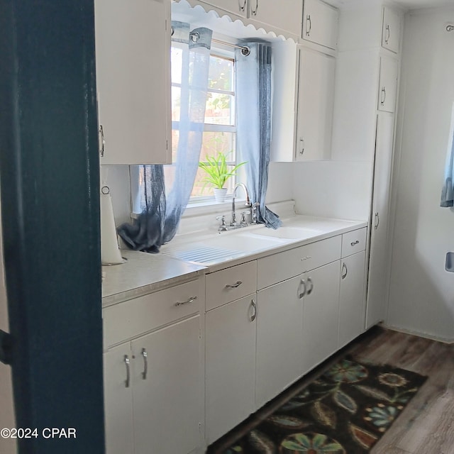 326 Massalina Dr, Panama City, FL 32401 - kitchen with white cabinets, a sink, wood finished floors, and light countertops