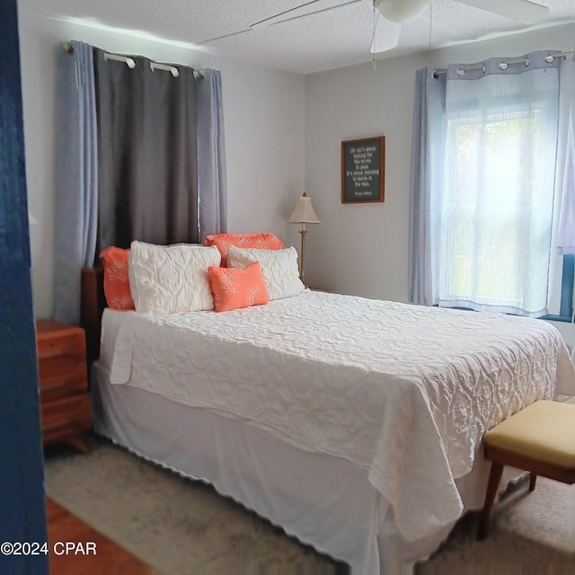 carpeted bedroom featuring a textured ceiling and ceiling fan