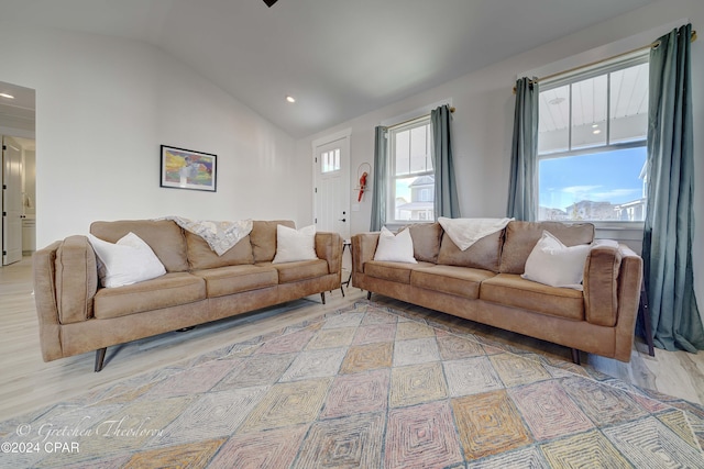 living room with light hardwood / wood-style floors and vaulted ceiling