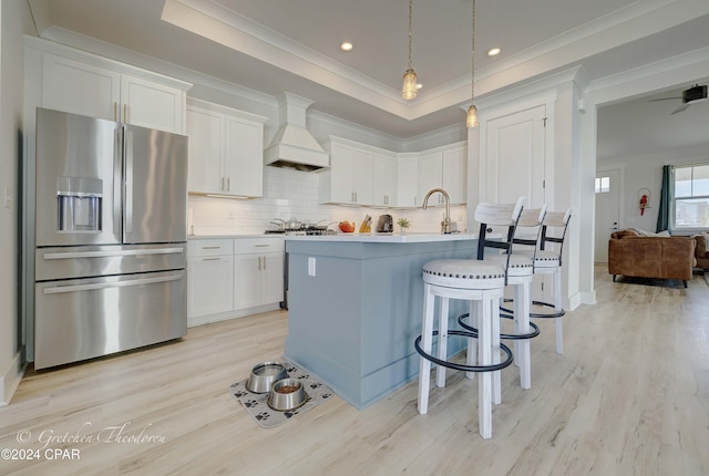 kitchen with white cabinetry, custom range hood, light hardwood / wood-style floors, and stainless steel refrigerator with ice dispenser