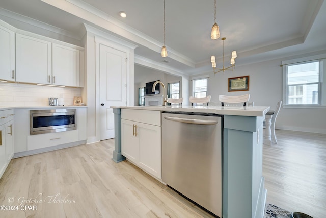 kitchen featuring appliances with stainless steel finishes, white cabinetry, and a healthy amount of sunlight