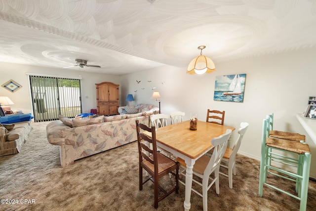 carpeted dining area with ceiling fan