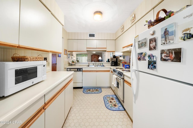 kitchen featuring sink, white cabinetry, and white appliances