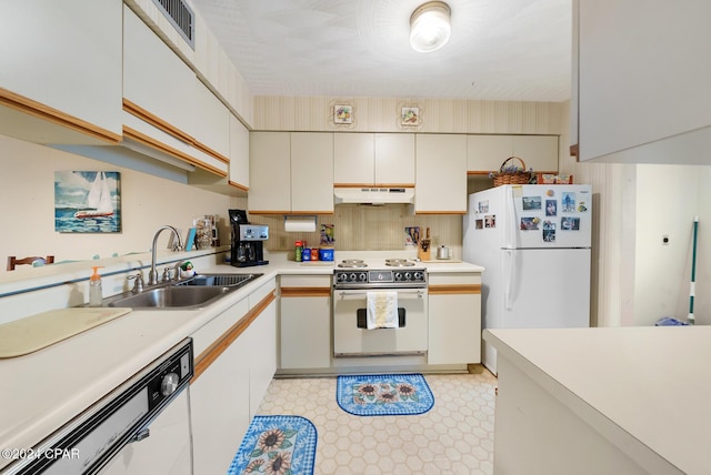 kitchen featuring sink, backsplash, white appliances, and white cabinets