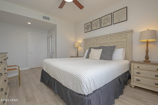 bedroom with a closet, light hardwood / wood-style floors, and ceiling fan