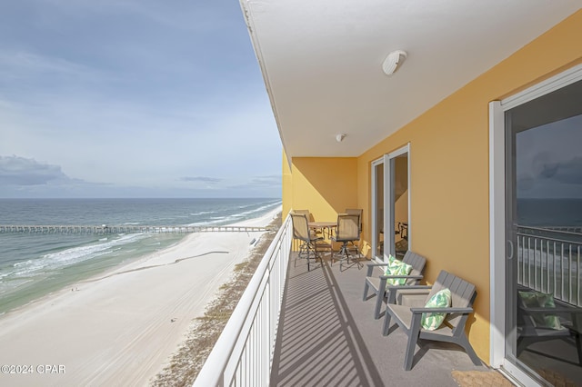 balcony featuring a water view and a view of the beach