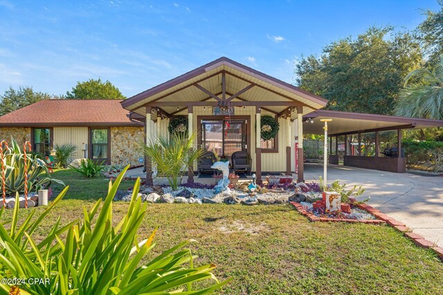 ranch-style house featuring a carport, covered porch, and a front lawn