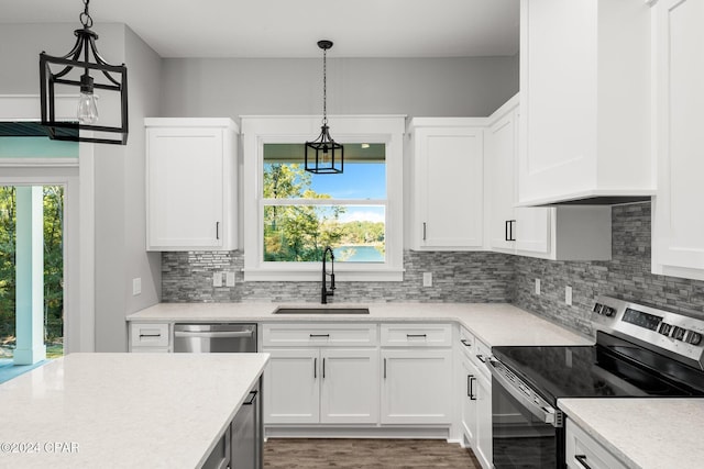 kitchen featuring sink, hanging light fixtures, a wealth of natural light, white cabinetry, and stainless steel appliances