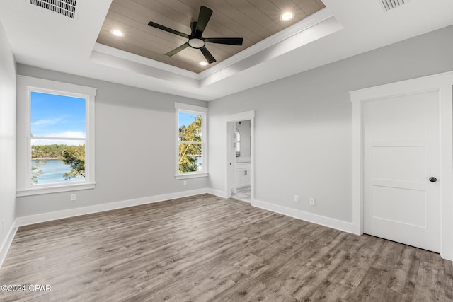 spare room with hardwood / wood-style floors, ceiling fan, ornamental molding, and a tray ceiling