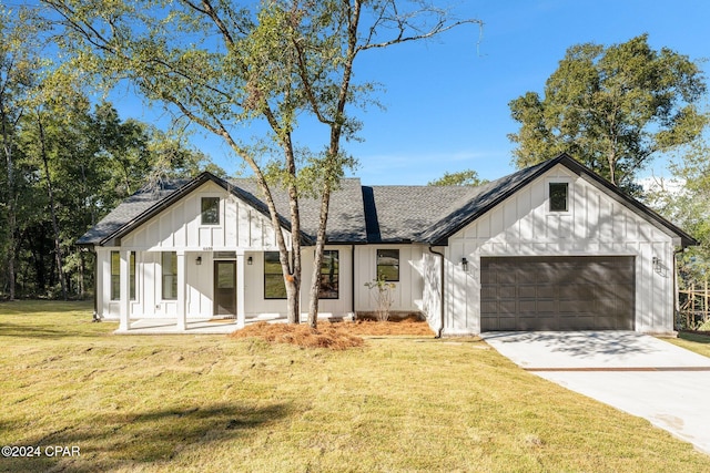 modern farmhouse style home with a front lawn, a porch, and a garage