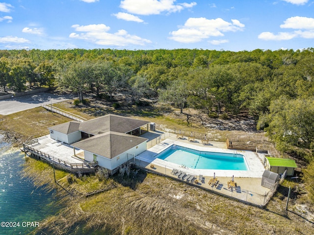 view of pool featuring a water view and a patio area