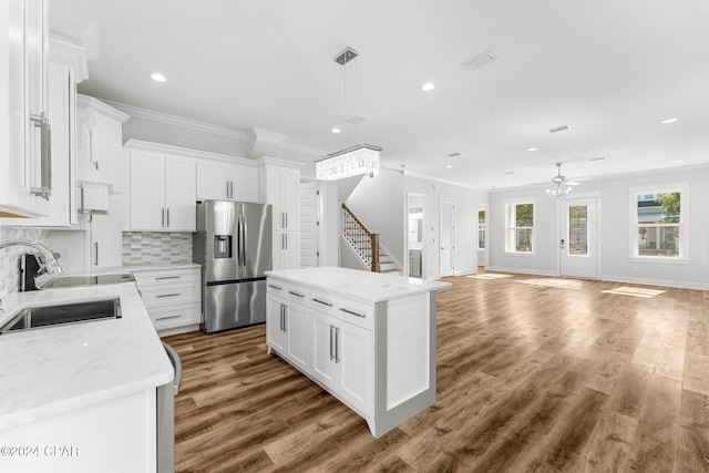 kitchen with white cabinetry, a center island, sink, and stainless steel fridge with ice dispenser