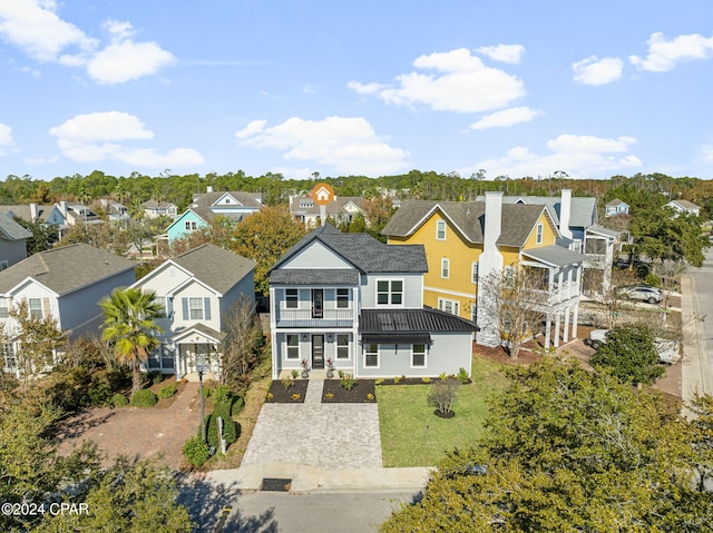 rear view of property featuring a yard, a balcony, and a porch