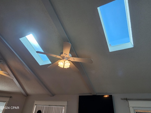 details featuring a skylight, ceiling fan, and beamed ceiling