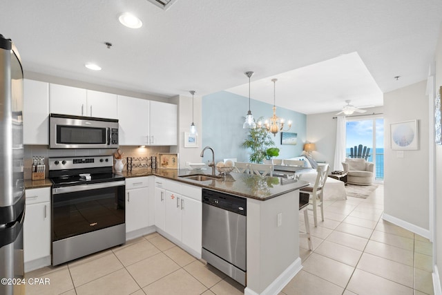 kitchen with kitchen peninsula, white cabinetry, sink, and stainless steel appliances