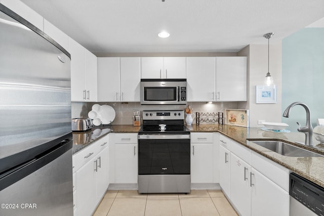 kitchen with dark stone countertops, white cabinetry, sink, and appliances with stainless steel finishes