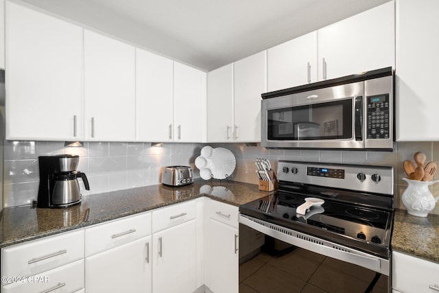 kitchen with decorative backsplash, tile patterned flooring, stainless steel appliances, and white cabinetry