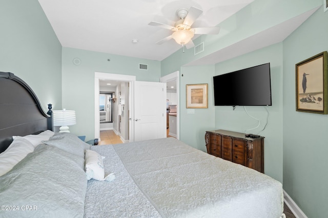 tiled bedroom featuring ensuite bathroom and ceiling fan