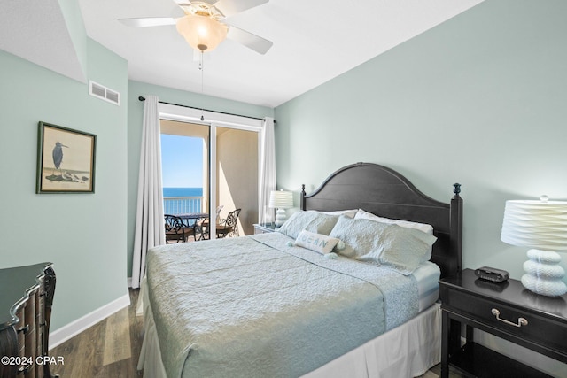 bedroom featuring ceiling fan, a water view, and dark hardwood / wood-style floors