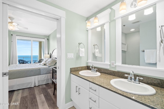 bathroom with hardwood / wood-style flooring, ceiling fan, a water view, and vanity