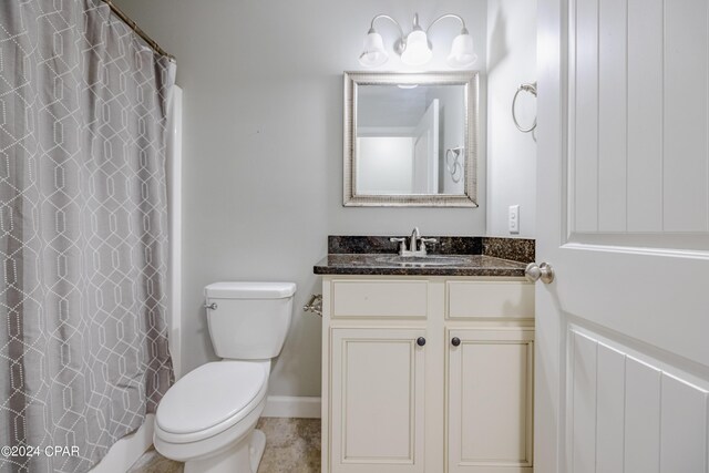 bathroom featuring vanity, toilet, and walk in shower