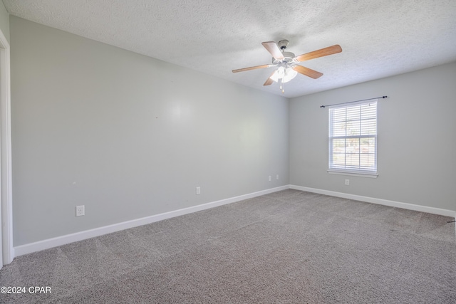 carpeted spare room featuring a textured ceiling and ceiling fan