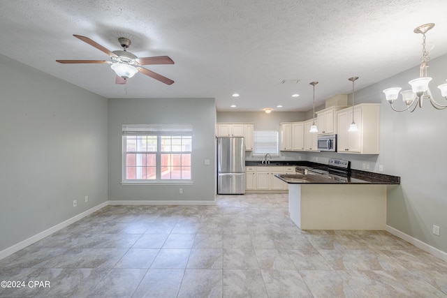 kitchen featuring kitchen peninsula, appliances with stainless steel finishes, white cabinets, and pendant lighting