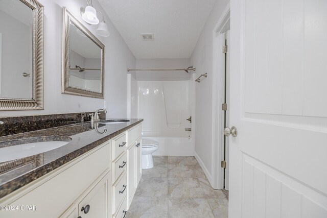 full bathroom with washtub / shower combination, a textured ceiling, vanity, and toilet