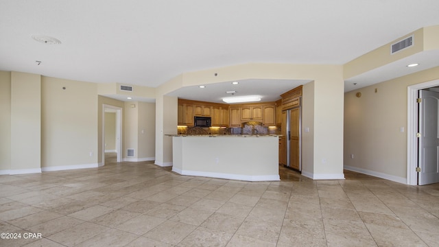 kitchen featuring decorative backsplash and stone counters