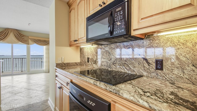 kitchen with light tile patterned flooring, light brown cabinets, tasteful backsplash, and black appliances