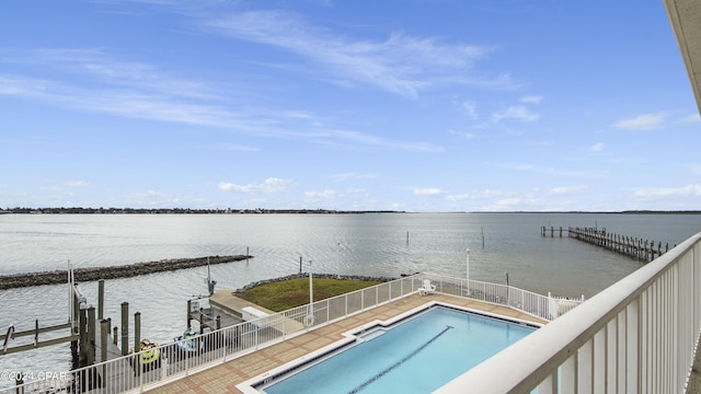 view of swimming pool featuring a boat dock and a water view